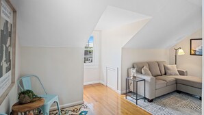 Una sala de estar moderna con un sofá, una silla, una mesita y una lámpara.