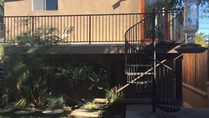 Ein zweistöckiges Gebäude mit Balkon und einer Wendeltreppe.