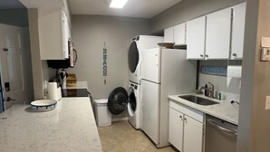 A compact kitchen with a built-in washer and dryer, a sink, and a countertop.