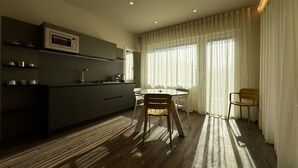 A modern kitchen with a microwave, cabinets, and a dining area with a table and chairs. - Skyline- Moncheri ( Studio apartment with a view) (Siena)