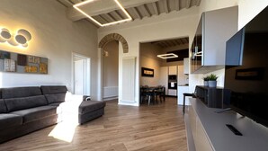 A modern living room with a sofa, a dining area, and a kitchen. - On the way to the sun ( Apartment with air conditioning) (Siena)
