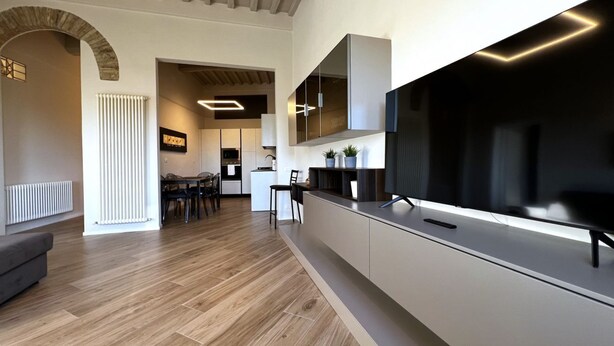 A modern kitchen with a large island, built-in appliances, and a flat-screen TV. - On the way to the sun ( Apartment with air conditioning) (Siena)