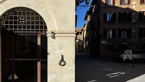 A stone building with a large arched entrance and a metal gate. - On the way to the sun ( Apartment with air conditioning) (Siena)