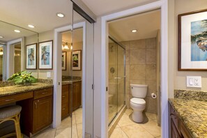 Ein modernes Badezimmer mit Duschkabine aus Glas, Toilette und Waschtisch mit Granitplatte.