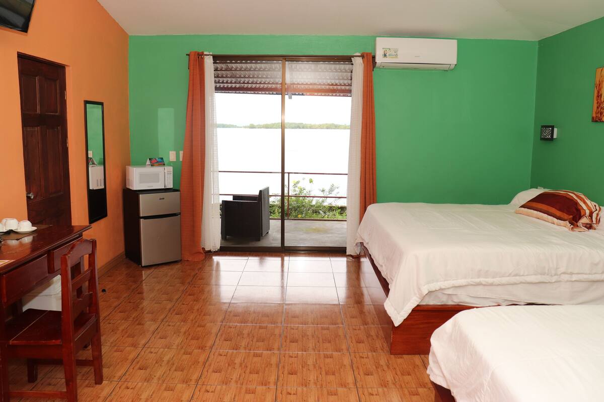 A room with a bed, a desk, a microwave, and a refrigerator.