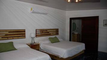 A hotel room with two beds, wooden headboards, a nightstand with a lamp, a marble floor, and a ceiling light fixture.