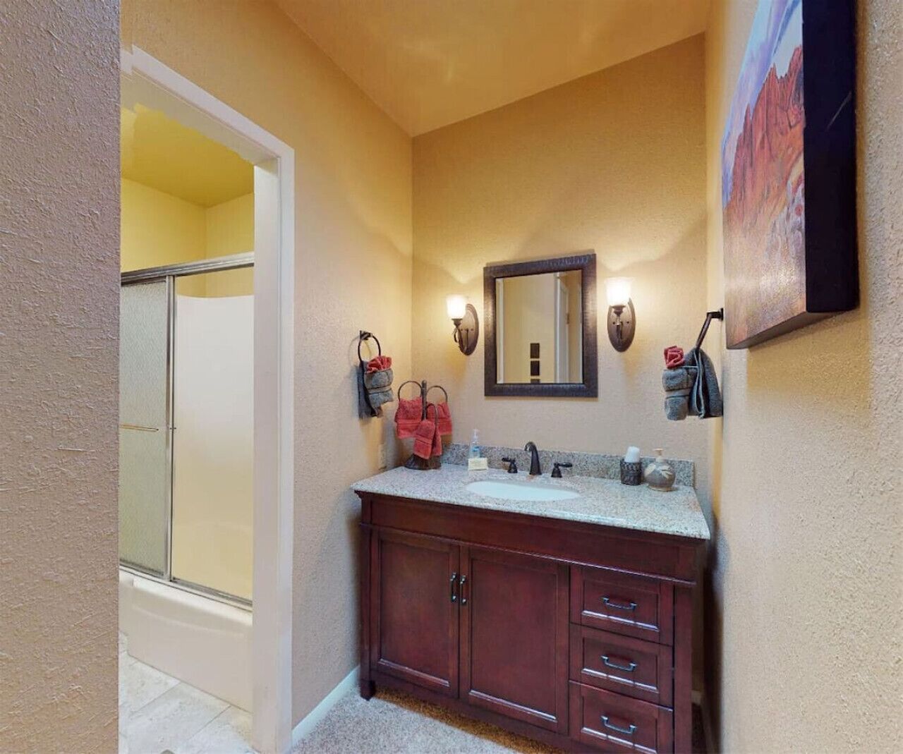 Un bagno con un doppio lavabo, una doccia e uno specchio grande.