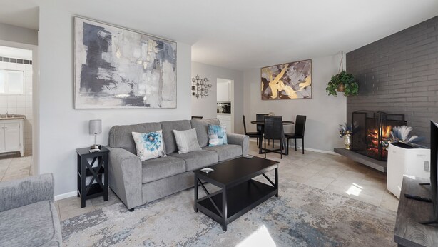 A modern living room with a grey sofa, black coffee table, and a fireplace. - Charming 2-bedroom apartment with WiFi, AC in Olympia (Olympia)