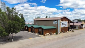 A Hansen Inn & Cabins with a large building and several smaller cabins, a parking lot, and a clear sky. - 12-Hansen Inn & Cabins, Room, Single King, Second Floor, No Pets, No Smoking (Wall)