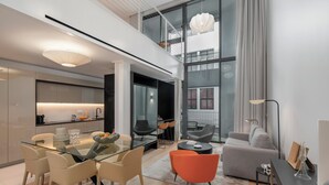 En moderne stue med et glasbord, behagelige siddepladser, en sofa og et sofabord.