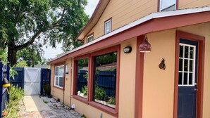 A house with a paved driveway, a garage, and a front door with a small window.
