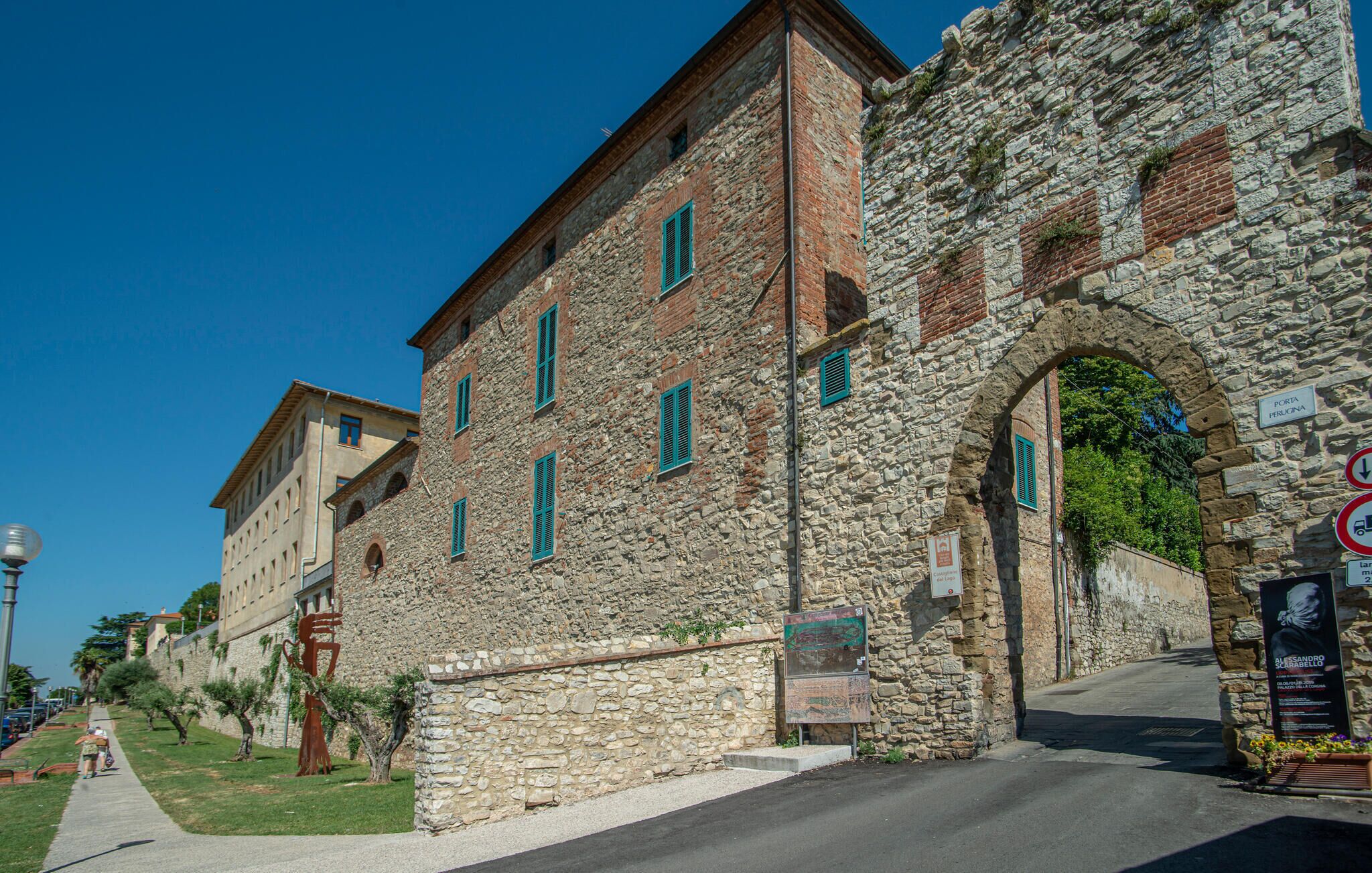 A stone building with multiple windows and an archway, likely a historical site.