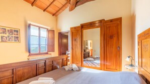 Un dormitorio con una cama grande, un armario de madera y una ventana con cortinas.