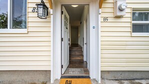 La entrada de una casa con una escalera de madera que conduce a una puerta con el número 85.
