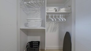 A white closet with shelves, a hanging rack, and a laundry basket. - Modern Suite Near Royal Alex Hospital, LRT, Rogers|Free WiFi, Parking & Netflix (Edmonton)