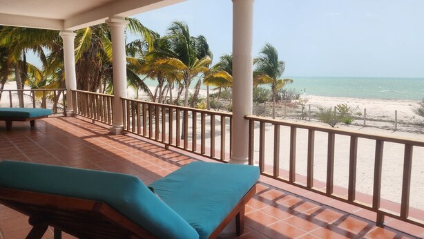 A balcony with a view of the beach and palm trees. - Ocean Front, Accessible, 3-bdrm Home!  (Celestún)