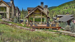 A modern lodge with large windows, a wooden deck, and a mountainous backdrop. - Heaven`s Gate Luxury Ski-In/Out in Lewis Ranch (Copper Mountain)