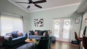 Ein Wohnzimmer mit Sofa, Couchtisch und Deckenventilator.