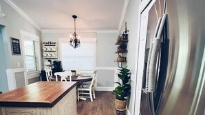 Eine Küche mit einer Holzinsel, einem Edelstahlkühlschrank und einem Schild mit der Aufschrift ‚Kaffee‘ an der Wand.