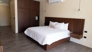 Une chambre d’hôtel moderne dotée d’un grand lit, d’une armoire intégrée et d’un système de climatisation.