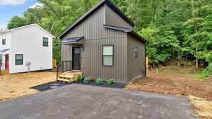 Une maison à deux étages au design moderne, dotée d’un porche à l’avant et d’une petite terrasse.