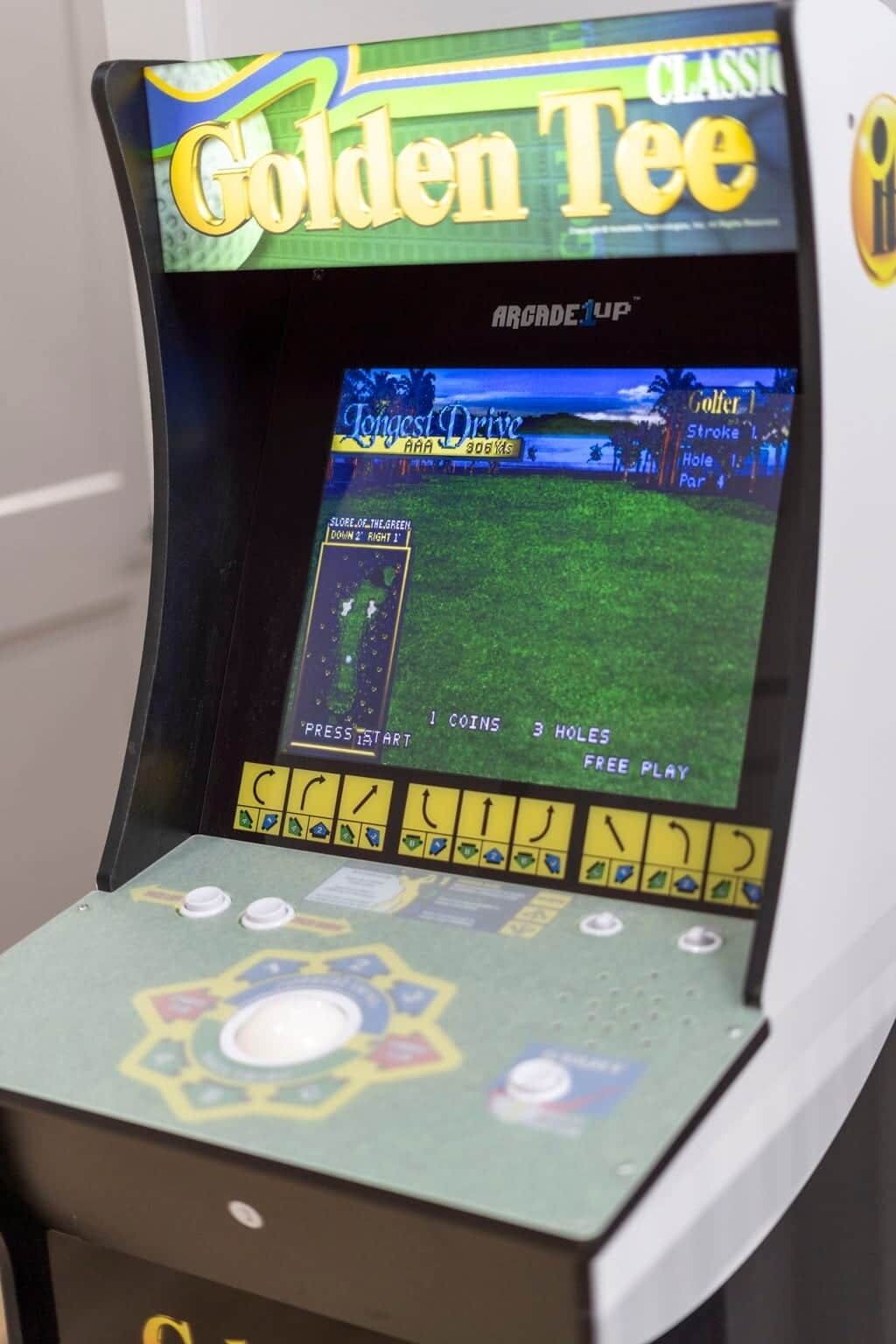 A vintage arcade game titled 'Golden Tee' with a screen displaying a golf game interface.