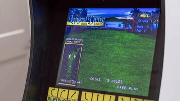 A vintage arcade game titled 'Golden Tee' with a screen displaying a golf game interface.