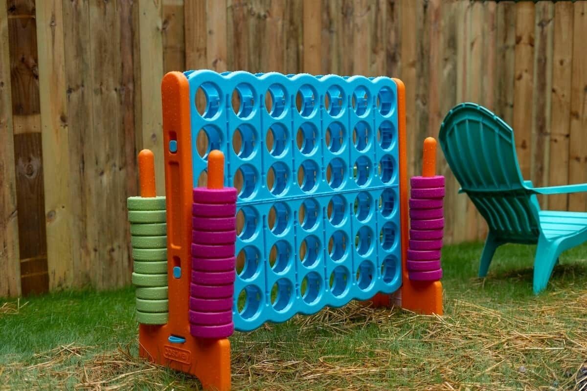 Un juguete tipo pop-it azul y naranja, con una silla verde de fondo.