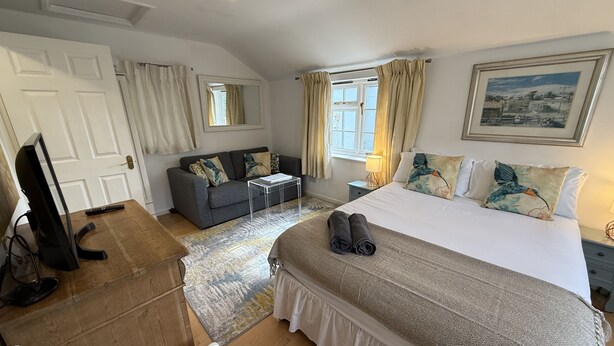 Une chambre d’hôtel avec un grand lit, un canapé, un bureau et une télévision.