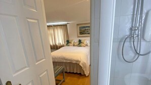 Une chambre d’hôtel avec un lit, une douche et une porte donnant sur une autre pièce.