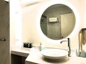 A modern bathroom with a round mirror, a white sink, and a towel rack. - Lindo Dpto 3hab Jesus Maria cerca a San Isidro (Lima)