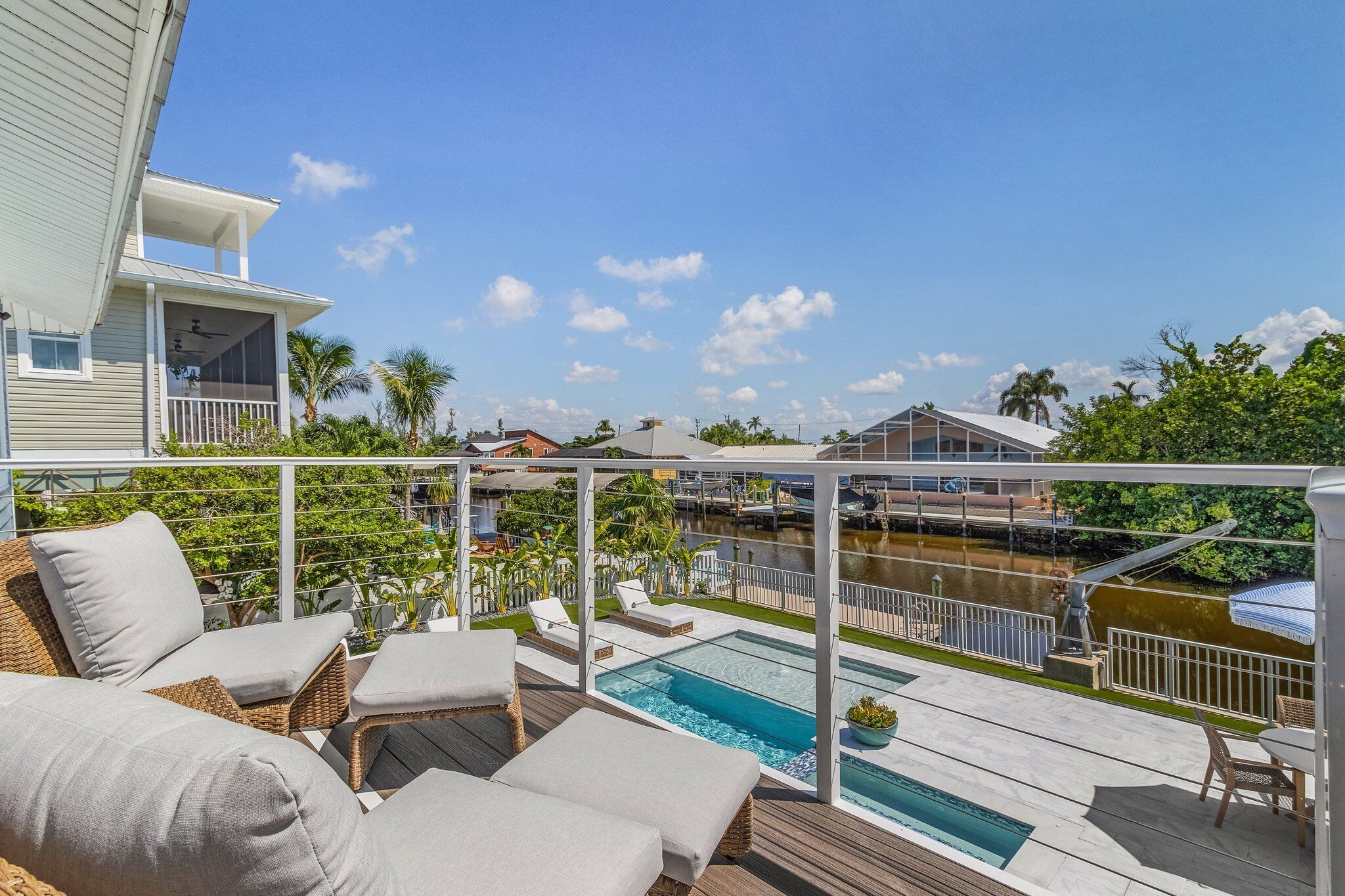 A rooftop pool area with lounge chairs and a view of a marina.