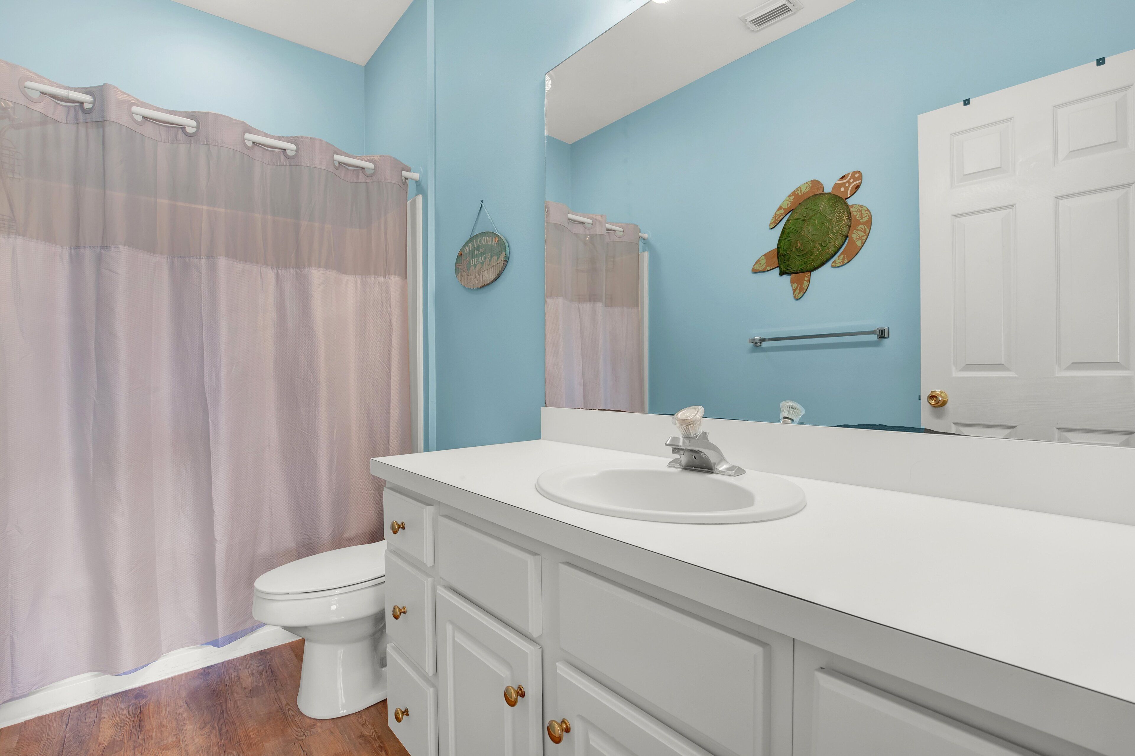 Un baño con tocador blanco, lavamanos y retrete.