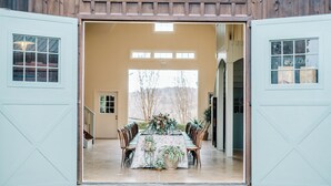 Un bâtiment de style grange, ouvert sur l’extérieur, avec un espace aménagé pour prendre un repas.