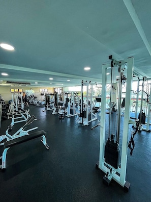 A gym with various exercise machines and equipment.