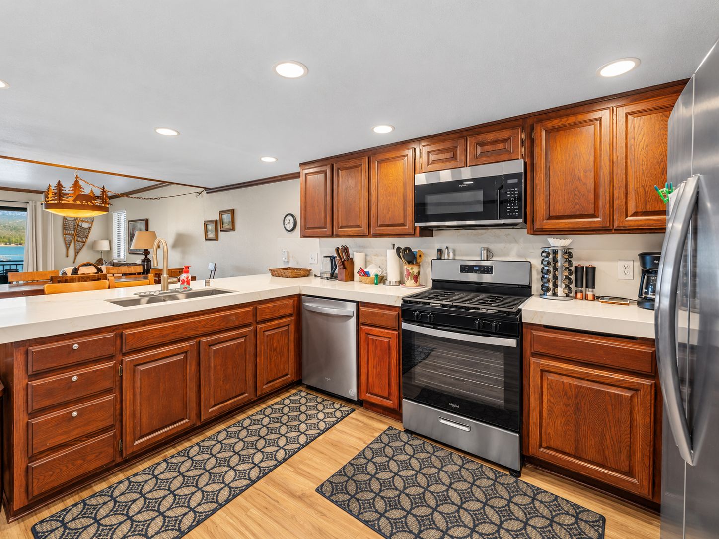 A modern kitchen with wooden cabinets, stainless steel appliances, and a large island with a sink.