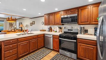 A modern kitchen with wooden cabinets, stainless steel appliances, and a large island with a sink.