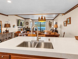 A kitchen with a large island, stainless steel sink, and wooden furniture. - Shores Lakefront Condo - Lakefront Condo, Walk to Village, Dock, Pool (Big Bear Lake)