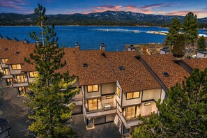 A residential area with multiple houses, a lake, and mountains in the background. - Shores Lakefront Condo - Lakefront Condo, Walk to Village, Dock, Pool (Big Bear Lake)
