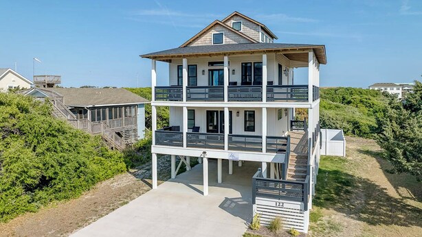 A multi-story beachfront house with a balcony on each floor, a covered porch, and a view of the ocean. - Wright Off The Beach | 1020 ft to the beach | Private Pool (Kill Devil Hills)
