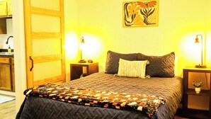 A bedroom with a bed, two bedside tables, a nightstand, a door, and a wall-mounted artwork. - Elevated Ski Chalet at Powderhorn Mountain (Bessemer)