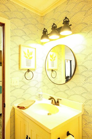 A bathroom with a sink, mirror, and wall-mounted lights. - 1BR + Sofa Bed · Balcony · Near Powderhorn (Bessemer)
