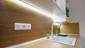 Een moderne badkamer met een houten wastafelmeubel, een witte wasbak en een ingebouwde spiegel.