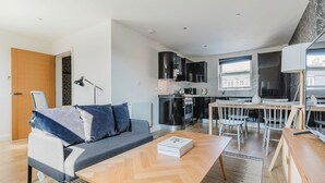 A modern apartment with a living area, kitchenette, and dining space. - Luxe Marylebone 2BR, Modern Furniture & Decor, by Blueground (London)