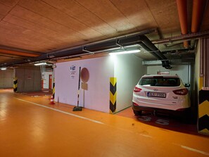 An underground parking garage with a white car parked in a spot marked with the number 35.