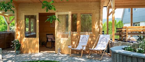 Eine Holzjagdhaus mit Veranda, einem Stuhl und einem Tisch.