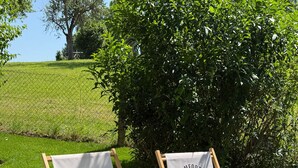 Two wooden lounge chairs with white fabric and 'Cosy Comfort Living Apartments' printed on them, placed on a grassy lawn with a hedge in the background. - Apartment 'Bergblick' with Shared Terrace, Sauna, Whirlpool & Pool (Stockach)