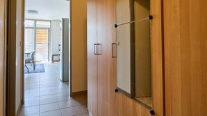Um corredor com portas de madeira e um espelho grande.