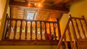 Un balcon en bois avec une balustrade, une fenêtre et un escalier.