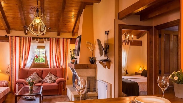 Un salon chaleureux avec un canapé, une table basse et une table à manger pour deux personnes.